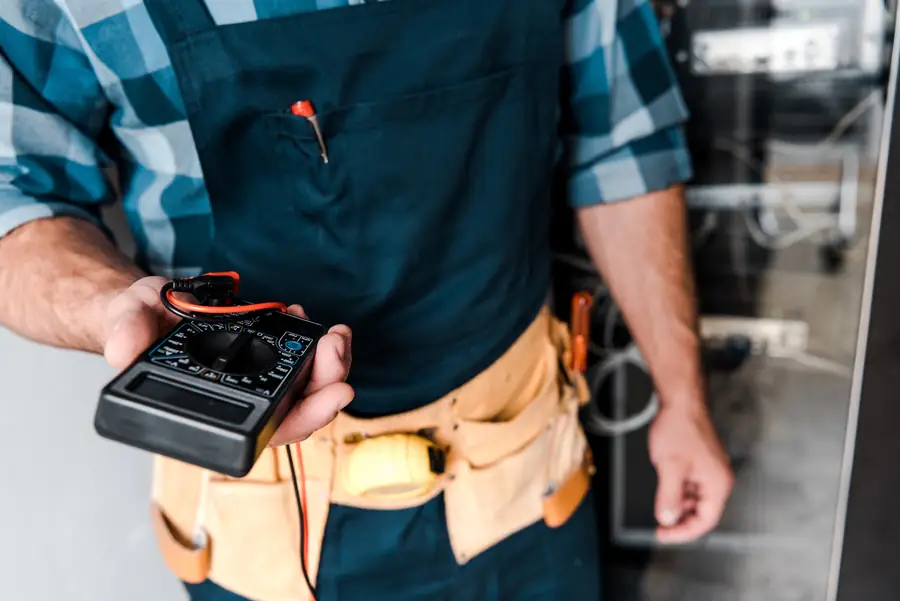 Elektricien met multimeter en gereedschapsriem